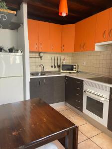 a kitchen with orange cabinets and a wooden table at HAPPY HOUSE NANE in Playa Honda