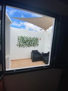 a window view of a living room with a plant on a wall at HAPPY HOUSE NANE in Playa Honda