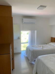 Habitación de hotel con 2 camas y ventana en Flat Beira Mar Ancorar Porto de Galinhas, en Porto de Galinhas