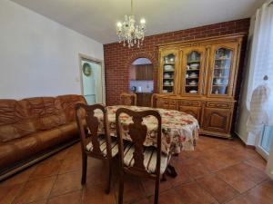uma sala de jantar com uma mesa e um sofá em Apartments and room Suza em Senj
