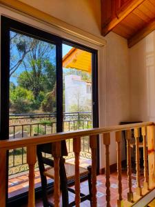 um quarto com uma varanda com uma grande janela em Mini Casa Colibri em Mazamitla
