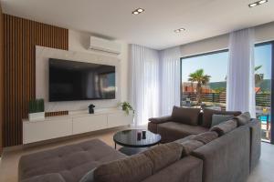 ein Wohnzimmer mit einem Sofa und einem Flachbild-TV in der Unterkunft Villa Noa Cubus in Stara Novalja
