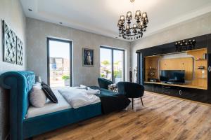 une chambre avec un lit bleu et un salon dans l'établissement Apartament Glamour Vip, à Ustka