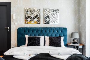 - un grand lit avec une tête de lit bleue dans une chambre dans l'établissement Apartament Glamour Vip, à Ustka