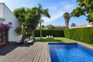 un patio trasero con piscina y terraza de madera en Casa Azahar y Casa Buganvilla, en Gandía