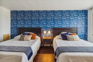 Duas camas num quarto com papel de parede azul em Breath taking Lake Views 5 min to DT Petoskey em Petoskey