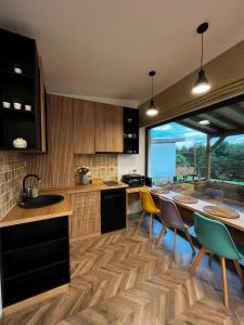 巴亞德菲耶爾的住宿－Transalpina Tiny House - outdoor jacuzzi，一个带桌椅和大窗户的厨房