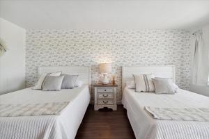 Duas camas num quarto com paredes brancas em Million Dollar Sunset Views of Petoskey Bay em Petoskey