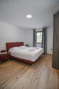 a bedroom with a large bed and a wooden floor at Chalet HerMes arT in Idrija