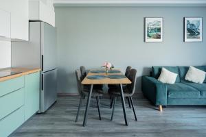 a kitchen and dining room with a table and a couch at GreenForest Apartament Baile Felix in Baile Felix