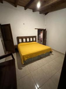 a bedroom with a yellow bed in a room at Hotel del Pozo in San Sebastián del Oeste