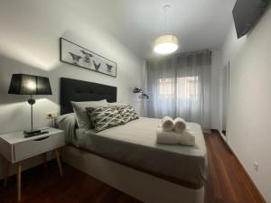 1 dormitorio con 1 cama con 2 toallas en LALIN CENTRO URBANO, CÓMODO Y FUNCIONAL, en Lalín