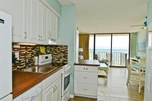cocina con armarios blancos y vistas al océano en Oceanfront Suite Private Balcony Top Location, en Myrtle Beach