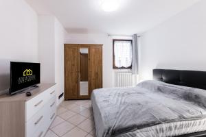 une chambre avec un lit et une télévision à écran plat dans l'établissement Aosta Centre Apartments - Croce di Città 88, à Aoste