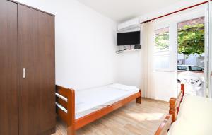 a small bedroom with a bed and a window at Apartmani i sobe Radojičić in Bijela