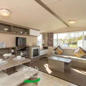 ein Wohnzimmer mit einem Sofa und einem Tisch in der Unterkunft Home from Home Lettings at Tattershall Lakes - The Green in Tattershall