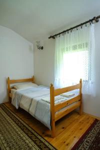 a bedroom with a wooden bed with a window at Kuća Poljanice in Visoko