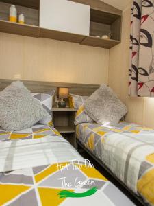 En eller flere senge i et værelse på Home from Home Lettings at Tattershall Lakes - The Green