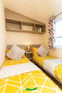 two beds sitting next to each other in a room at Home from Home Lettings at Tattershall Lakes - The Green in Tattershall