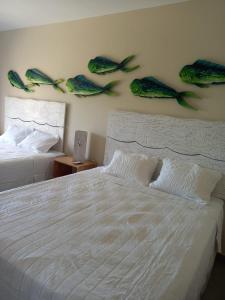 een slaapkamer met twee bedden met vis aan de muur bij Kuluka Resort And Spa in San Miguel