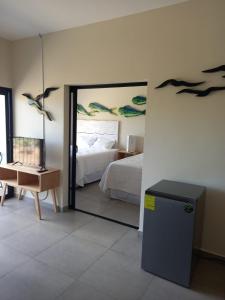 a bedroom with a bed and a mirror with birds on the wall at Kuluka Resort And Spa in San Miguel