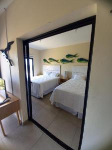a mirror reflection of a bedroom with two beds at Kuluka Resort And Spa in San Miguel