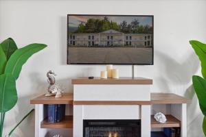 5mins to DT Petoskey Lakefront 50 inches 4K TV في بتوسكي: غرفة معيشة مع تلفزيون على منصة مع موقد