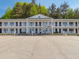 un aparcamiento vacío frente a un gran edificio blanco en 5mins to DT Petoskey Lakefront 50 inches 4K TV, en Petoskey