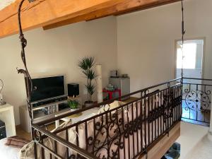 ein Wohnzimmer mit einem Balkon und einem TV in der Unterkunft Chambre d’hôtes Soleil Levant in Six-Fours-les-Plages