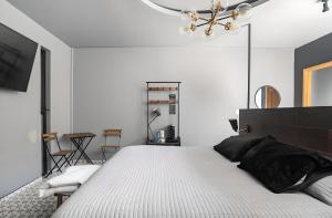 um quarto com uma grande cama branca e um lustre em The Studios 22800 em Ensenada