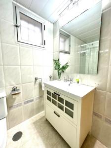 a white bathroom with a sink and a mirror at Apartamento Claudio Marcelo, 1 in Córdoba