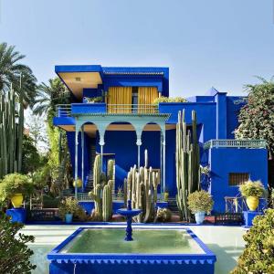 ein blaues Haus mit einem Brunnen davor in der Unterkunft The Downtown Jewel - Centre Marrakech in Marrakesch