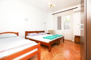 sypialnia z 2 łóżkami i oknem w obiekcie Apartmani i sobe Radojičić w mieście Bijela