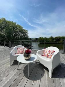 2 sedie e un tavolo con cuscini su una terrazza di Gîte de charme bord de Meuse a Namur