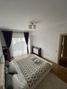 een slaapkamer met een groot bed en een bank bij YamaLuxe Apartments - Home-Like Apartment (in Buna Ziua) in Cluj-Napoca