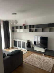 a living room with a couch and a flat screen tv at YamaLuxe Apartments - Home-Like Apartment (in Buna Ziua) in Cluj-Napoca