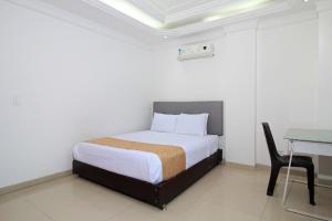 ein Schlafzimmer mit einem Bett, einem Tisch und einem Stuhl in der Unterkunft Hotel Abi Inn By GEH Suites in Cartagena de Indias