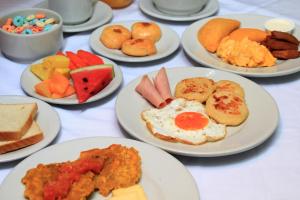 a table with plates of breakfast foods on them at Hotel Abi Inn By GEH Suites in Cartagena de Indias