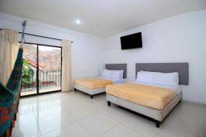 a bedroom with two beds and a television in it at Hotel Abi Inn By GEH Suites in Cartagena de Indias +52 photos