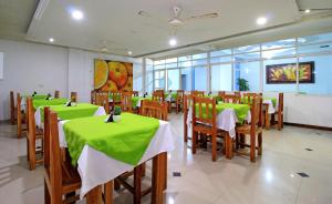 a restaurant with tables and chairs with green table cloth at Hotel Abi Inn By GEH Suites in Cartagena de Indias