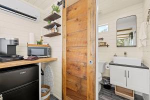eine Küche mit Holztür in einem winzigen Haus in der Unterkunft New The Sunrise Cozy Container Home in Fredericksburg