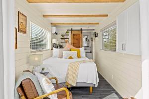 a small bedroom with a bed and a chair at New The Sunrise Cozy Container Home in Fredericksburg