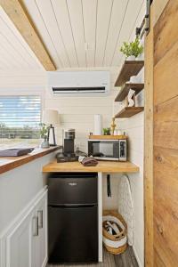 a kitchen with a black refrigerator and a microwave at New The Sunrise Cozy Container Home in Fredericksburg