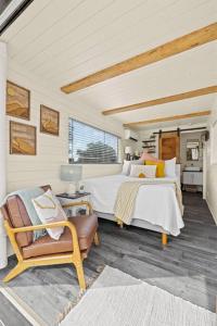 a bedroom with two beds and a chair at New The Sunrise Cozy Container Home in Fredericksburg