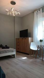 een woonkamer met een bed, een tv en een tafel bij I5 studio in Ioannina
