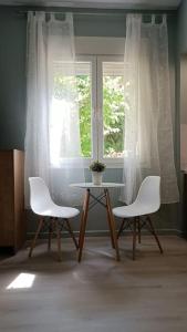 twee witte stoelen en een tafel voor een raam bij I5 studio in Ioannina
