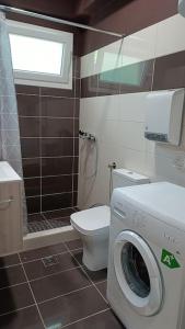 een badkamer met een wasmachine en een toilet bij I5 studio in Ioannina