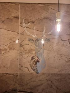a vase with branches on a marble wall with a light fixture at הברון baron in Rishon LeẔiyyon