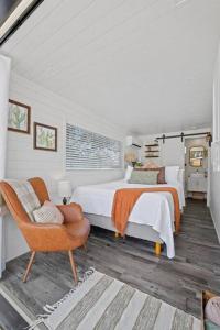 a white bedroom with two beds and a chair at New The Saguaro-Tiny Shipping Container Home in Fredericksburg