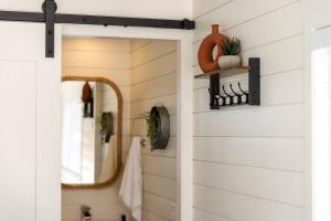 a bathroom with a white door and a mirror at New The Saguaro-Tiny Shipping Container Home in Fredericksburg
